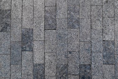 Asfalt kaldırım. Gri kaldırımlı tuğla arka plan. Kaldırım dokusu dış zemin kare granit geçit, üst manzara. Kaldırım taşlı yol inşaatı