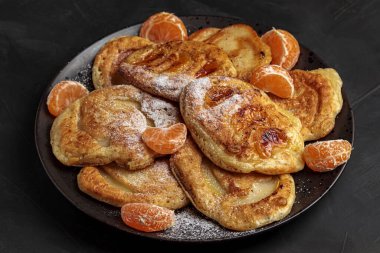 Çatallı lezzetli gözleme kahvaltısı. Karamelli mandalinalı fırın, elma. Tatlı krep, üstünde pudra şekeri olan ev yapımı tatlı. Yumuşak İngiliz Sabah Dalı