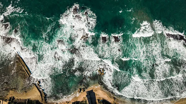 Okyanus dalgalarının ve berrak mavi suyun havadan görünüşü
