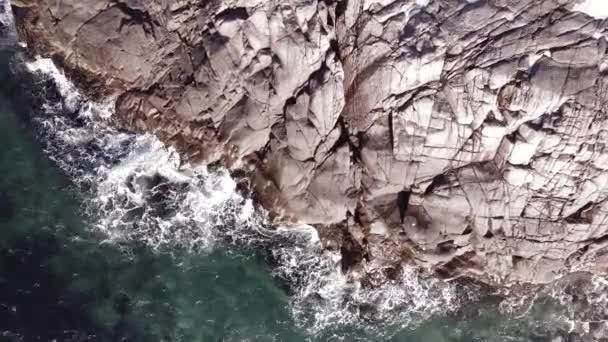 Vuelo aéreo de invierno superior sobre las olas rodando en la orilla ártica del océano con piedras redondas, olas del océano en la tormenta — Vídeo de stock