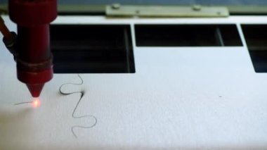 Oyuncak fabrikasında otomatik tahta yapboz üretimi. Lazer ışınıyla kontrplak keserken çekilmiş 4K makro görüntü. Tahta oyuncaklar tasarım konsepti