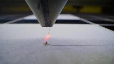 Oyuncak fabrikasında otomatik tahta yapboz üretimi. Lazer ışınıyla kontrplak keserken çekilmiş 4K makro görüntü. Tahta oyuncaklar tasarım konsepti
