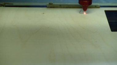 Oyuncak fabrikasında otomatik tahta yapboz üretimi. Lazer ışınıyla kontrplak keserken çekilmiş 4K makro görüntü. Tahta oyuncaklar tasarım konsepti