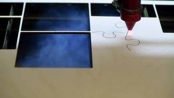 Oyuncak fabrikasında otomatik tahta yapboz üretimi. Lazer ışınıyla kontrplak keserken çekilmiş 4K makro görüntü. Tahta oyuncaklar tasarım konsepti — Stok video