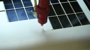 Oyuncak fabrikasında otomatik tahta yapboz üretimi. Lazer ışınıyla kontrplak keserken çekilmiş 4K makro görüntü. Tahta oyuncaklar tasarım konsepti