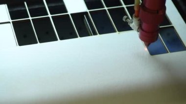 Oyuncak fabrikasında otomatik tahta yapboz üretimi. Lazer ışınıyla kontrplak keserken çekilmiş 4K makro görüntü. Tahta oyuncaklar tasarım konsepti