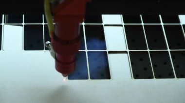 Oyuncak fabrikasında otomatik tahta yapboz üretimi. Lazer ışınıyla kontrplak keserken çekilmiş 4K makro görüntü. Tahta oyuncaklar tasarım konsepti