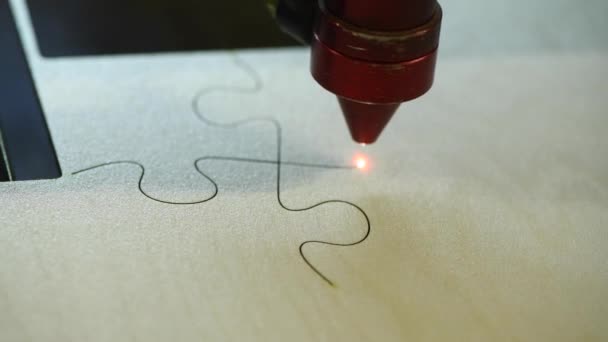 Producción automática de rompecabezas de madera en la fábrica de juguetes. Imágenes macro hdr 4k de corte de madera contrachapada con rayo láser. concepto de diseño de juguetes de madera — Vídeos de Stock