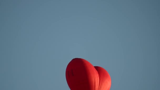 Farverige varm luft hjerteform ballon flyver på solnedgang over blå himmel i slowmotion, Happy Valentines Day koncept. 4k HDR Høj kvalitet optagelser – Stock-video