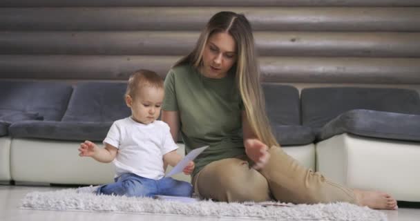 Heureux jeune mère et bébé fils jouant avec la carte alphabet sur le sol chaud à la maison, l'éducation précoce à la maison. — Video