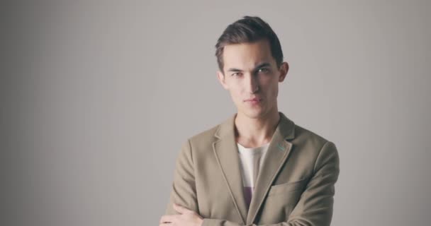 Junger gutaussehender kaukasischer Mann gestikuliert, um aufzuhören. Studioporträt auf grauem Hintergrund — Stockvideo