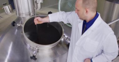 Biranın yoğunluk ölçümü. Bira fabrikasında bira test eden bira üreticisi. Yavaş çekim