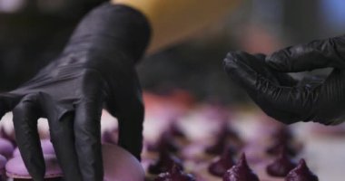 Kurabiye ve Fransız tatlısı hazırlama süreci. İçi doldurulmuş iki yarım parçalı montaj. Siyah eldivenli eller.