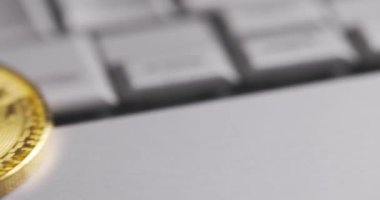 Bitcoin BTC kripto para birimi. Laptop klavyesinde altın sikkeler, makro çekimler ve çevirmeler. Bozuk paralar düşer