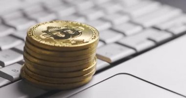 Bitcoin BTC kripto para birimi. Dizüstü bilgisayarda altın para yığını, klavyede makro çekim ve çevirme ile.