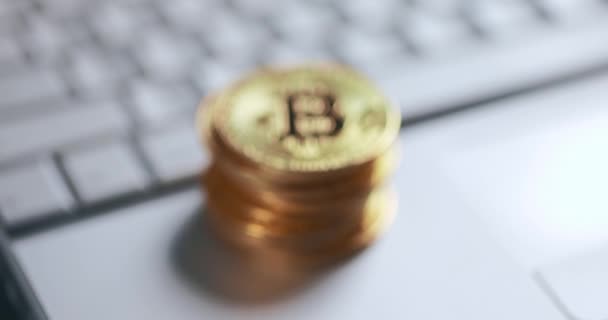 Bitcoin BTC криптовалюта. Стек золотых монет на клавиатуре ноутбука. Дефокусировка — стоковое видео