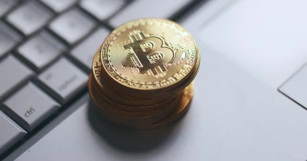 Bitcoin BTC kriptovaluta. Egy halom arany érme a laptop billentyűzetén. A kéz teszi az érmét. — Stock videók