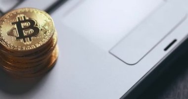Bitcoin BTC kripto para birimi. Dizüstü bilgisayarda altın para yığını, klavyede makro çekim ve çevirme ile.