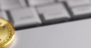 Bitcoin BTC kripto para birimi. Laptop klavyesinde altın sikkeler, makro çekimler ve çevirmeler. Bozuk paralar düşer
