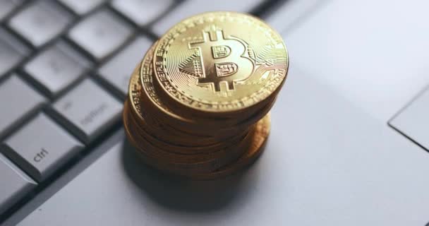 Bitcoin BTC κρυπτονόμισμα. Στοίβα από χρυσά νομίσματα στο πληκτρολόγιο laptop. Το χέρι παίρνει το νόμισμα — Αρχείο Βίντεο