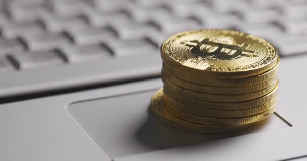 비트코인 BTC 암호화 통화. 금색 동전들이 노트북 키보드 위에 쌓여 있습니다. 손으로 하는 피라미드 — 비디오