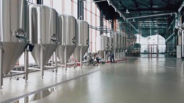 Modern bira fabrikasında parlak metal bira tankları. Geniş açı panoramik görüntü, kamera hareket ediyor