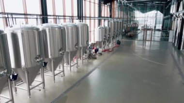 Modern bira fabrikasında parlak metal bira tankları. Geniş açı panoramik görüntü, kamera hareket ediyor