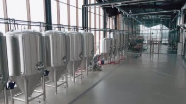 Modern bira fabrikasında parlak metal bira tankları. Geniş açı panoramik görüntü, kamera hareket ediyor