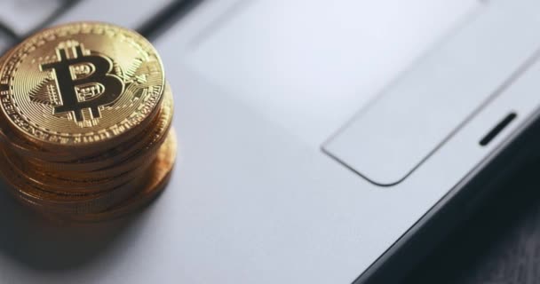 Kryptowährung Bitcoin BTC. Stapel Goldmünzen auf Laptop-Tastatur, Makroaufnahme mit Schwenken. — Stockvideo