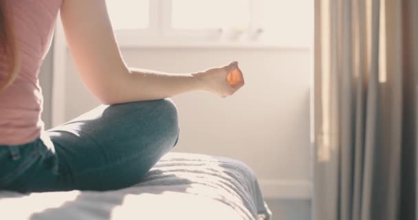 Молодая привлекательная женщина, занимающаяся утренней тренировкой дома. Деталь выстрел руки женщина сидит в лотос поза йоги медитации — стоковое видео