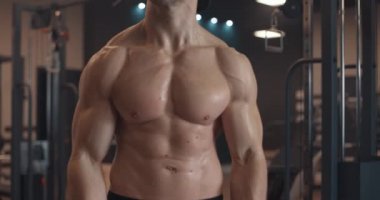 Yakışıklı, beyaz tenli, kaslı, spor salonunda bar, spor salonu ve vücut geliştirme konseptiyle kaslarını şişiren atletik erkekler. Yavaş çekim