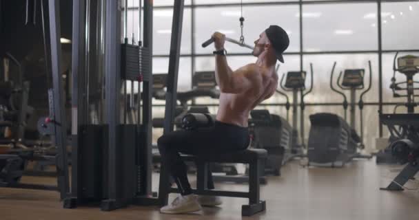 Спортсмен без сорочки молодий спортсмен робить вправи з гантелі в спортзалі. Красиві чоловіки підкачують м'язи біцепсів. Повільний рух — стокове відео