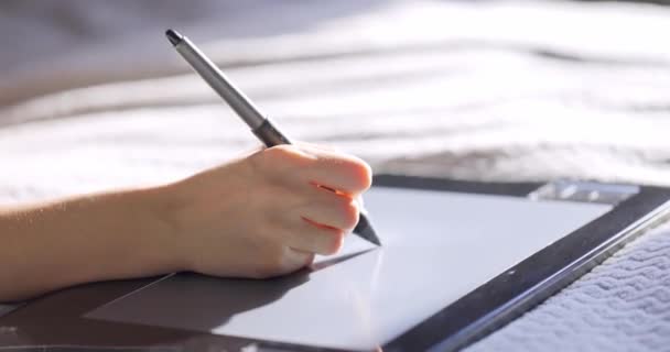 Close-up weergave van de hand van de vrouw met behulp van digitale tablettekening met stylus pen. Ontwerper die thuis aan bed werkt. — Stockvideo
