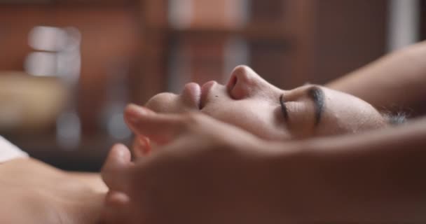 Masaje facial en salón de spa de belleza. Cuidado de la piel, bienestar, tratamiento de belleza. Movimiento lento — Vídeo de stock