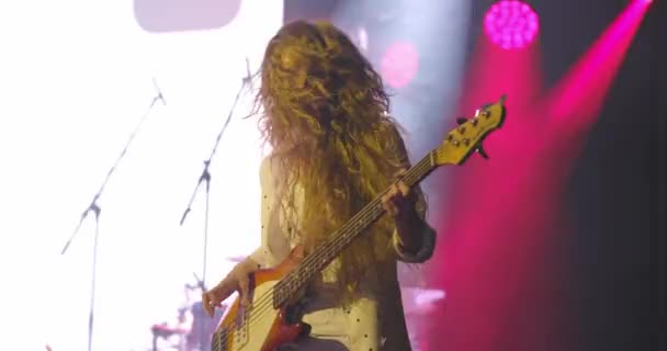 Kobieta gitarzysta na koncercie rockowym Gra gitarę elektryczną na otwartej scenie. Potrząsając głową, Slow Motion — Wideo stockowe