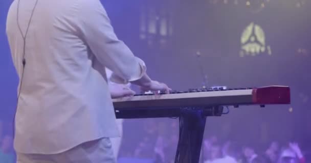 Un musicista suona un sintetizzatore in un gruppo musicale. La vista posteriore di pianista effettua il gioco di tastiera vivo in una banda. Rallentatore — Video Stock