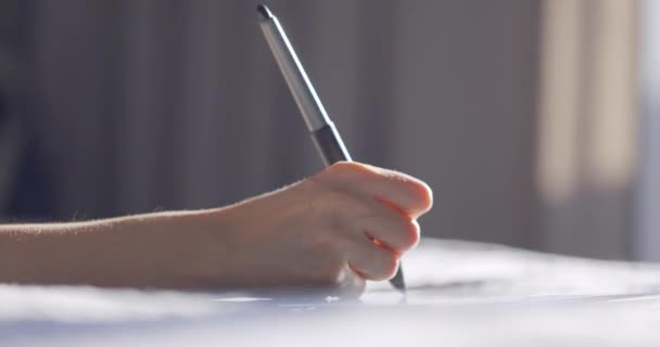 Stylus kalemle dijital tablet resim çizen kadın eli görüntüsünü kapat. Tasarımcı evde yatakta çalışıyor.. — Stok video