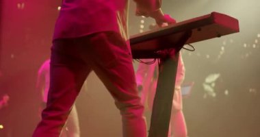 Bir müzisyen bir müzik grubunda sentezleyici çalar. Piyanistin arka planı bir grupta canlı klavye oyunu icra eder. Yavaş çekim