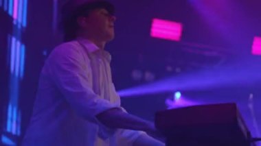 Man Musician konserde synthesizer çalıyor. Parlak Sahne Işığı. 