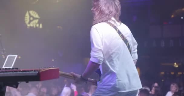 Back View of Guitarist at a Rock Concert Plays Chitarra elettrica sul palco. Una vocalist sullo sfondo. Rallentatore — Video Stock