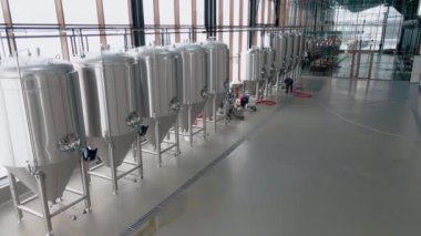 Modern bira fabrikasında parlak metal bira tankları. Geniş açı panoramik görüntü, kamera hareket ediyor