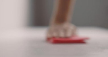 Kadın eli, masa yüzeyini pembe bir bezle temizliyor. Yavaş çekim