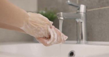 Kadın ellerini sabun ve sıcak suyla yıkıyor. Hijyen kavramı. Yakın plan. Yavaş çekim