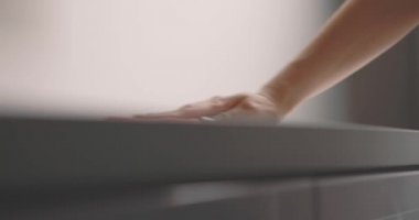 Kadın eli, masa yüzeyini pembe bir bezle temizliyor. Yavaş çekim