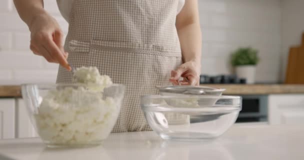 Jovem mulher coloca queijo cottage na tigela em casa cozinha. Processo de preparação de bolo de Páscoa. Close-up, câmera lenta — Vídeo de Stock