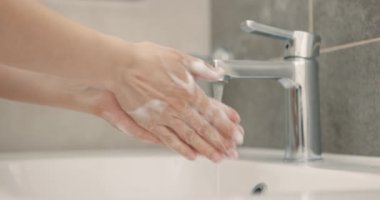 Banyo lavabosunda sabun ve suyla ellerini yıkamak. Yavaş çekim