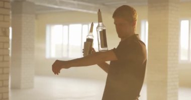 Ağır çekimde içki şişesiyle denge numaraları yapan profesyonel bir barmen. Barmen parlak güneş ışığında şişe hokkabazlığı yapıyor.