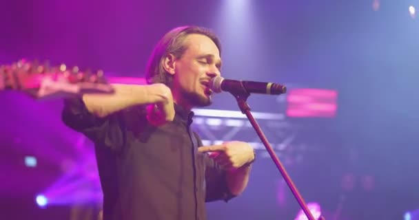 Cântăreaţă expresivă cântând la microfon. Concert de muzică live în fața luminilor luminoase colorate pe scenă — Videoclip de stoc