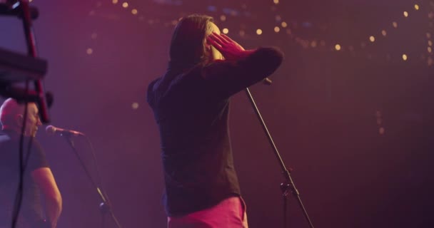 Vista trasera del cantante cantando en el micrófono. Concierto de música en vivo. Movimiento lento — Vídeos de Stock