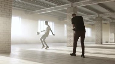 Sahne arkasında. Seçim sistemli genç adam siyahi futbolcuyu eğitirken video çekiyor.